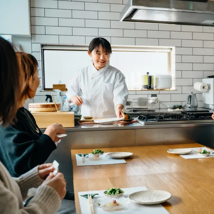 出張寿司の現場でお客様に料理を提供するまひろさん
